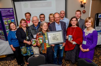 Directors of the Columbia Basin Environmental Education Network present Columbia Basin Trust with the 2014 Award of Excellence in Environmental Education and Communication. In photo back (left to right) Susie MacDonald, Wild Voices for Kids Program Manager; Erika Momeyer, Director, CBEEN; Yann Loranger, Director, CBEEN; Neil Muth President and CEO, Columbia Basin Trust; Ingrid Liepa, Vice-Chair, CBEEN; Dave Hillary, Board member, CBEEN; Duncan Whittick, Executive Director, CBEEN. Front (left to right) Kim Deane, Director, Columbia Basin Trust, Laurie Paige, Vice-Chair, Columbia Basin Trust; Greg Deck, Chair, Columbia Basin Trust; Gillian Cooper, Chair, CBEEN; Sonja Seher, Wild Voices for Kids Program Assistant.