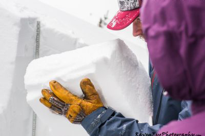 An Avalanche Canada public avalanche forecaster examines the snowpack (Photo courtesy of Raven Eye Photography.)